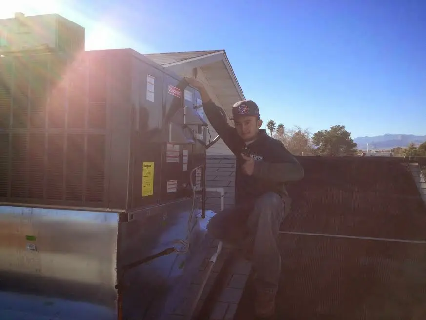 HVAC technician performing Air Duct Cleaning on a rooftop unit in Sammamish